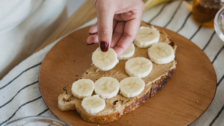 Perfectly baked banana bread with fresh bananas on a wooden table