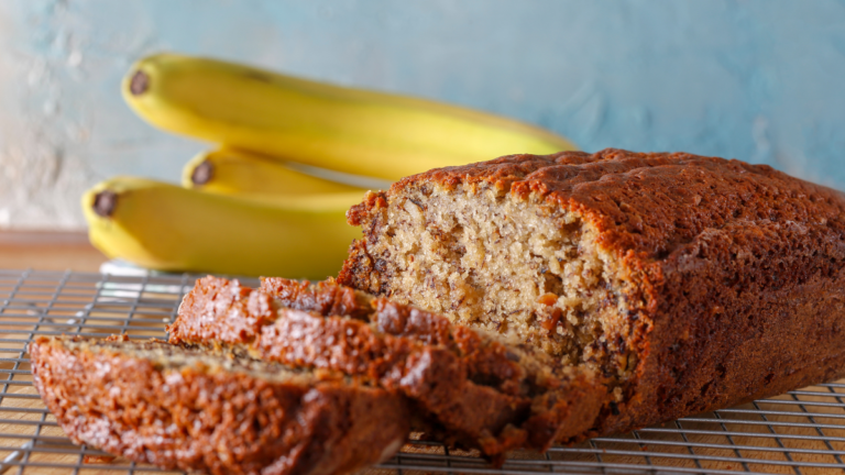 Banana bread slice on a wooden plate, highlighting a fluffy texture without using baking soda