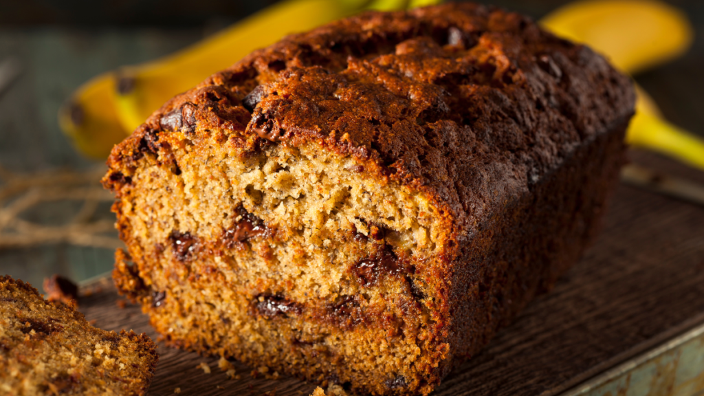 Freshly baked Starbucks banana bread with nuts and a moist texture, sliced on a wooden board.