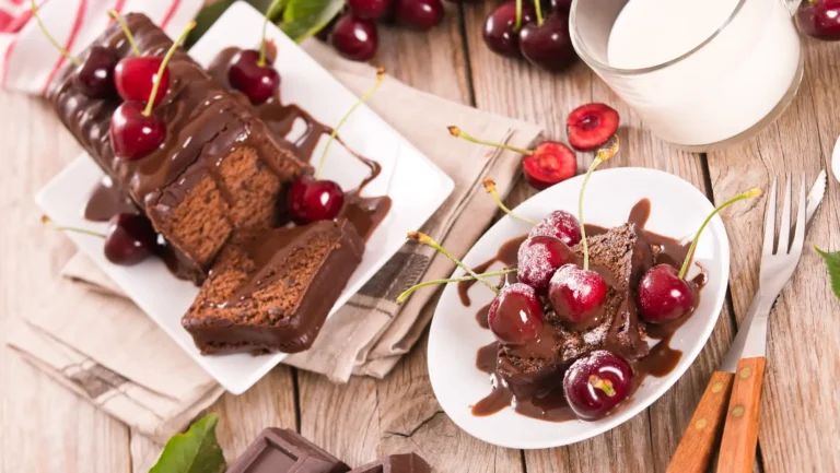 Moist and rich 5-star chocolate pound cake topped with chocolate ganache on a white plate.