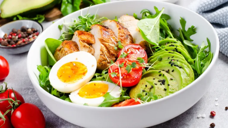 A hearty chicken breakfast skillet with eggs, vegetables, and fresh herbs served in a cast iron pan.