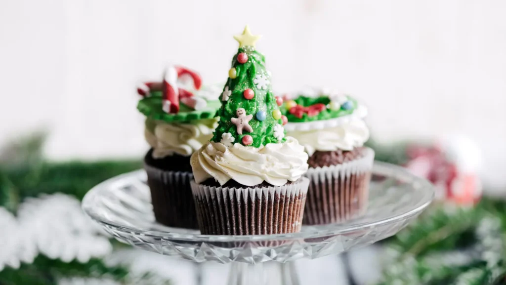 Christmas tree cake decorated with green frosting and festive ornaments.