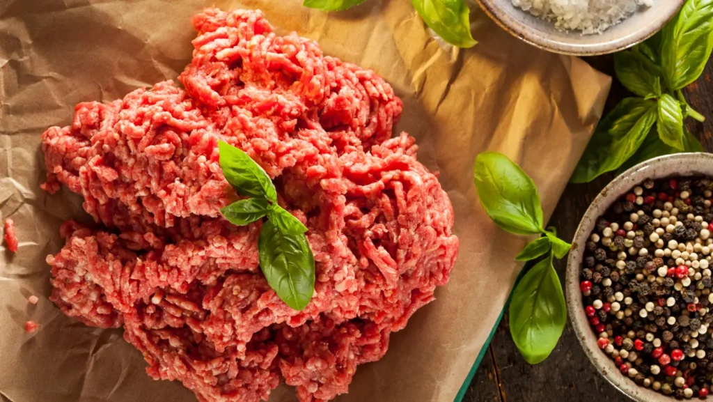 A plate of ground pork sausage with fresh vegetables, showcasing a balanced meal option.