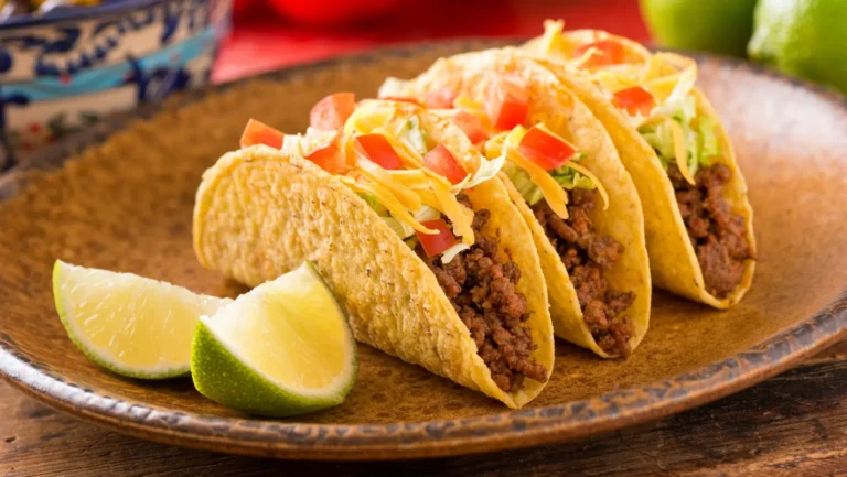 A vibrant plate featuring leftover taco meat repurposed into a taco salad with lettuce, cheese, salsa, and avocado slices.