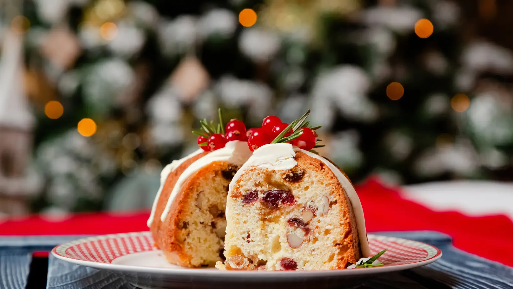 A beautifully decorated traditional Christmas cake with marzipan and festive toppings on a holiday-themed table.